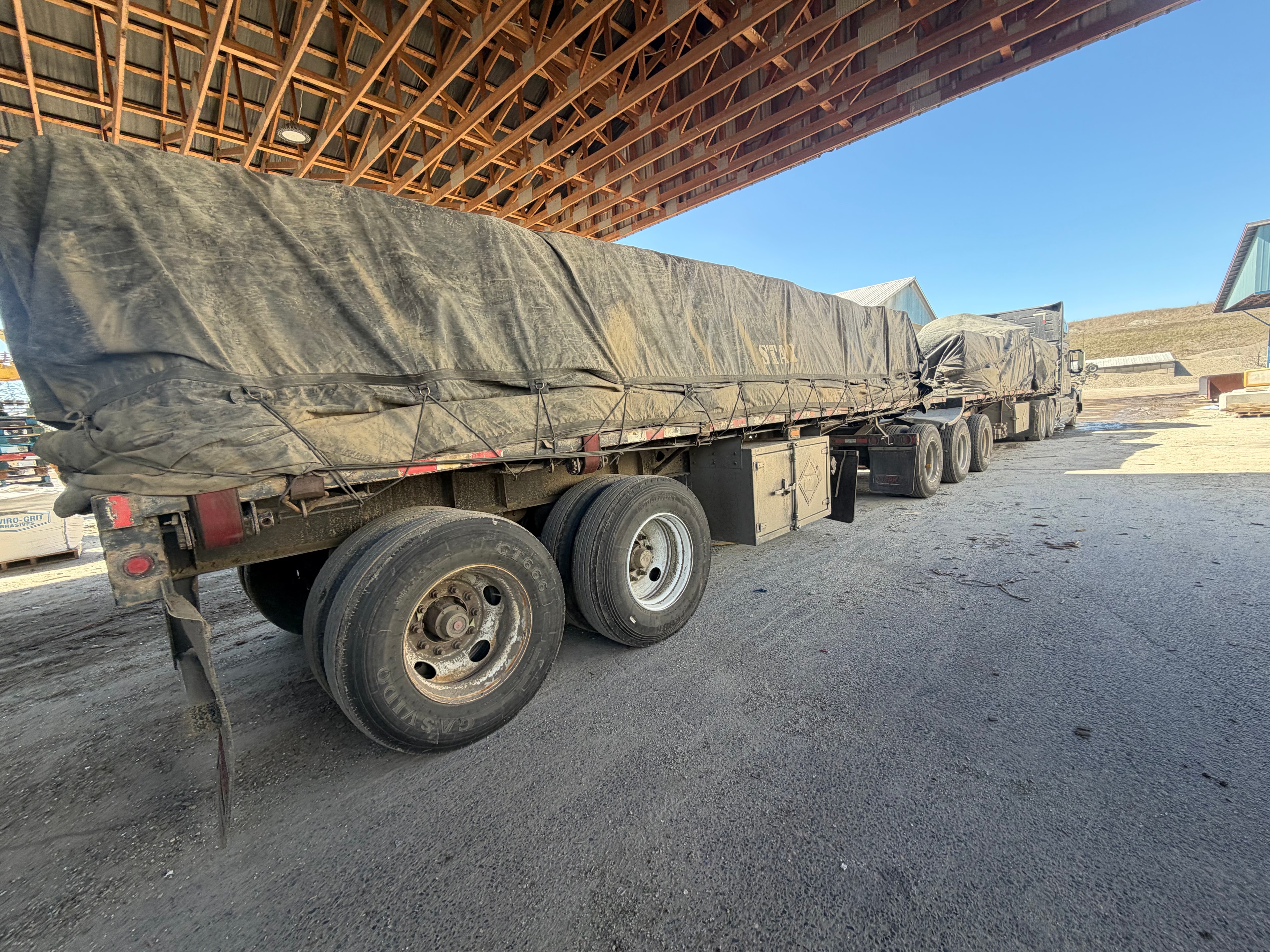 Flatbed trailer loaded with rebar and construction steel at job site